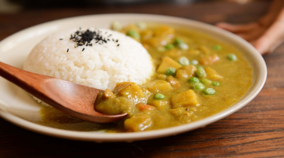 Curry being poured over rice